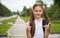 Portrait of happy girl with school bag standing outdoor. Little happy school girl going to school, back to school, education