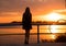 Portrait of happy girl silhouette contemplating sun at sunset on beach