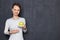 Portrait of happy girl smiling and pointing at saucer with ripe apple