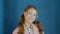 Portrait happy girl teenager smiling front camera on dark blue background. Face cute schoolgirl with curly hair tail