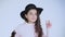 Portrait of happy girl weared in hat dances at camera on white background