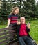 Portrait of happy granddaughter and grandfather  sitting on a bench