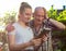 Portrait of happy granddaughter and grandfather using digital tablet