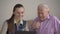 Portrait of happy grandfather and granddaughter using a tablet, smiling