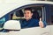 Portrait of happy guy, uber driver showing thumb up positive gesture, smiling gently to camera