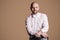 Portrait of happy handsome bearded bald man in light pink shirt