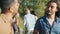 Portrait of happy handsome guys Arabs drinking from bottles and talking enjoying open air party in park