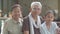 Portrait of happy healthy elderly retirement grandparents sitting together with adorable granddaughter and looking at camera.