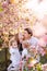 Portrait of a happy and healthy family on the background of a blooming apple tree in the garden.