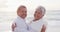 Portrait of happy hispanic just married senior couple embracing on beach at sunset