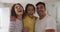 Portrait of happy hispanic parents and daughter standing embracing
