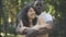 Portrait of happy hugging couple dating outdoors. Young loving Caucasian woman and African American man enjoying sunny