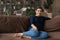 Portrait of happy Indian female renter relax on couch