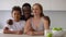 Portrait of happy interracial family of three. Spbi couple and mixed race son sit at kitchen