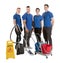 Portrait Of Happy Janitors With Cleaning Equipments