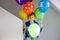 Portrait of happy kid boy with bunch on colorful air balloons on his birthday. Smiling school child having fun