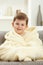 Portrait of happy kid sitting in oversize bathrobe