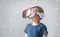 Portrait of happy kid in a virtual reality headset. Attractive kid using vr goggles over abstract background