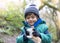 Portrait happy kid wearing winter clothes playing with dog toy in the park, Child explorer and learning about wild nature in