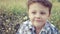 Portrait happy little boy sitting in the park