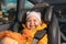 Portrait of a happy little kid sitting in a child seat in the back seat of a car. The concept of safe trip and child