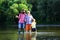 Portrait of happy little son, father and grandfather - three generations of men fishing on river. Grandfather and father