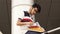 Portrait of a happy male asian student sitting on stairs and reading book