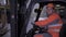 Portrait of happy male forklift truck driver in hard helmet and uniform looks at camera and smiles in warehouse