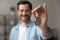 Portrait of happy man buyer of new apartment holding key