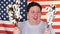 Portrait of happy man holding cotton branch on the background of an USA flag