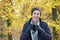 Portrait of a happy man in jacket scarf gloves hat smiling outdoors in autumn