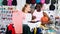 Portrait of happy man and woman holding sportswear in sporting g