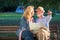 Portrait of happy man and woman reading map while sitting on a park bench. Senior couple on vacation using city map.