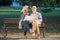 Portrait of happy man and woman reading map while sitting on a park bench. Senior couple on vacation using city map.