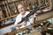 Portrait of a happy mature merchant with rifle in gun shop