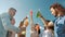 Portrait of happy men and women clanging bottles and drinking outside on beach