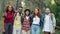 Portrait of happy men and women hugging looking at camera standing in forest