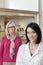 Portrait of happy mid adult optician and customer wearing glasses