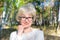 Portrait of a happy middle-aged woman walking in the park. Bright sunny summer day. The concept of freedom and joy