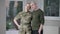 Portrait of happy military woman posing with husband at home in the evening. Middle aged Caucasian couple looking at