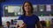 Portrait of happy mixed race female teacher standing in classroom with tablet children in background