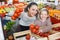 Portrait of happy mom and girl purchasing tomato