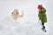 Portrait of happy mother and child playing snowball fight