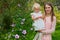 portrait of a happy mother with a girl,in the garden a little girl in the arms of a happy mother