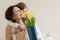 Portrait of happy mother and little daughter smiling and embracing, girl congratulates her mother with bouquet of flowers. Mom and