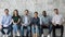 Portrait of happy multiracial candidates sit in row in hallway