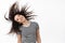 Portrait of happy natural brunette woman flip curly hair and smiling carefree, looking cheerful, standing against white