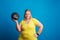 Portrait of a happy overweight woman holding a heavy ball in studio.
