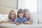 Portrait of happy parents lying with son in bed
