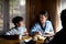 Portrait of happy poor small girl with parents eating indoors at home, poverty concept.